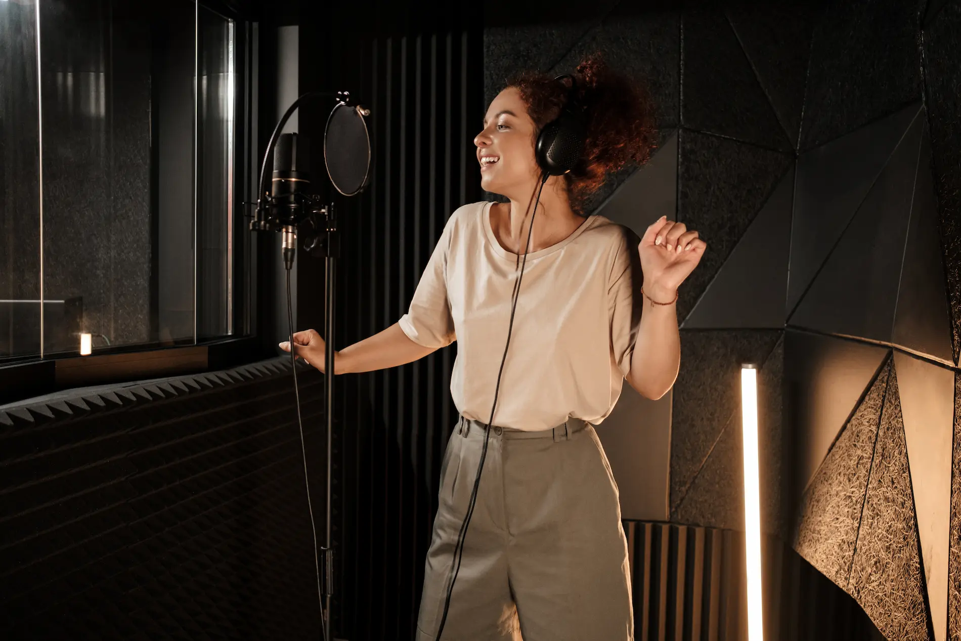 charming-female-musician-headphones-dreamily-dancing-while-recording-song-modern-sound-studio